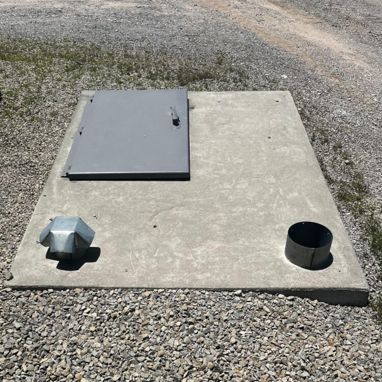 Concrete utility base with metal access cover and ventilation components